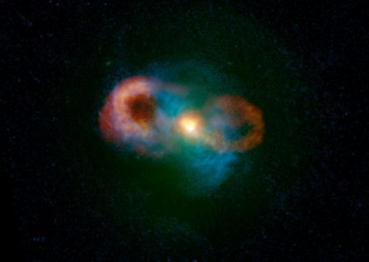 Kompositbild der Teacup-Galaxie. Grüne Farben zeigen Sternlicht, blaue zeigen das Gas und rote/gelbe Farben kennzeichnen die Radioemissionen. Die hellen Bereiche in der Bildmitte zeigen, wo die Jets von dem Schwarzen Loch erzeugt werden und auf das umgebende Gas treffen. (C. Harrison, A. Thomson; Bill Saxton, NRAO / AUI / NSF; NASA)