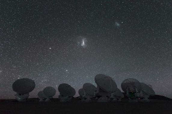 Die beiden Magellanschen Wolken am Nachthimmel über der Südhalbkugel, im Vordergrund die Antennen des Atacama Large Millimeter/ submillimeter Array (ALMA). (Credits: ESO / C. Malin)