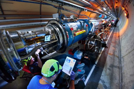 Zwei Mitglieder des LHC-Wartungsteams inspizieren und säubern ein Diodengehäuse eines Dipolmagneten, bevor sie die elektrische Isolierung verbessern. (Credits: Image: Maximilien Brice and Julien Ordan / CERN)