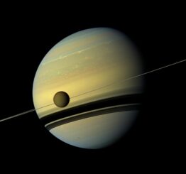 Saturns größter Mond Titan zieht vor dem Planeten und dessen Ringen vorbei. (Credits: NASA / JPL-Caltech / Space Science Institute)
